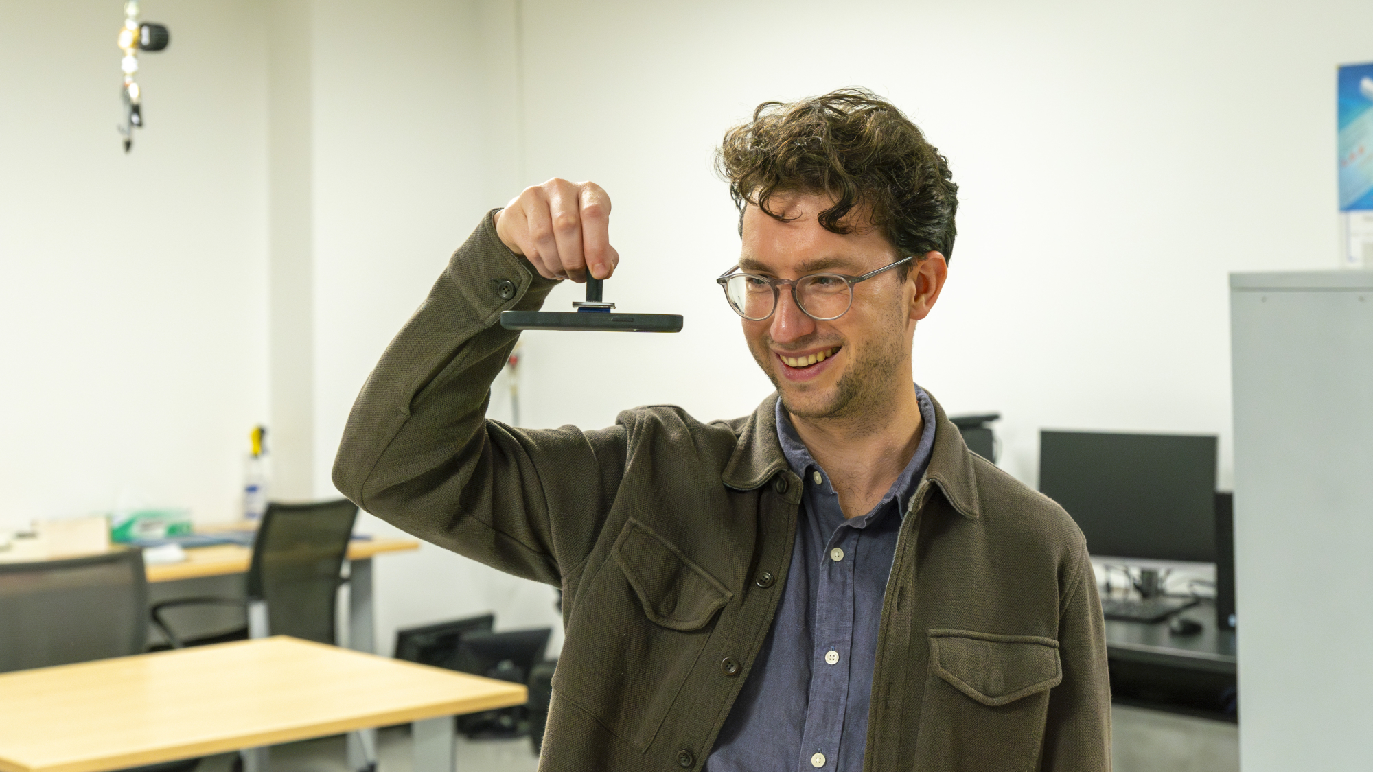 Dr. Jamie Booth using a test adhesive on a cellphone.